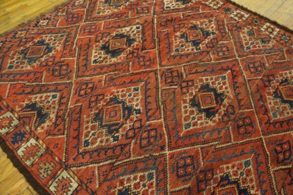 Close-up of a richly patterned, antique red and navy geometric rug by rugs on net. By rugs on net