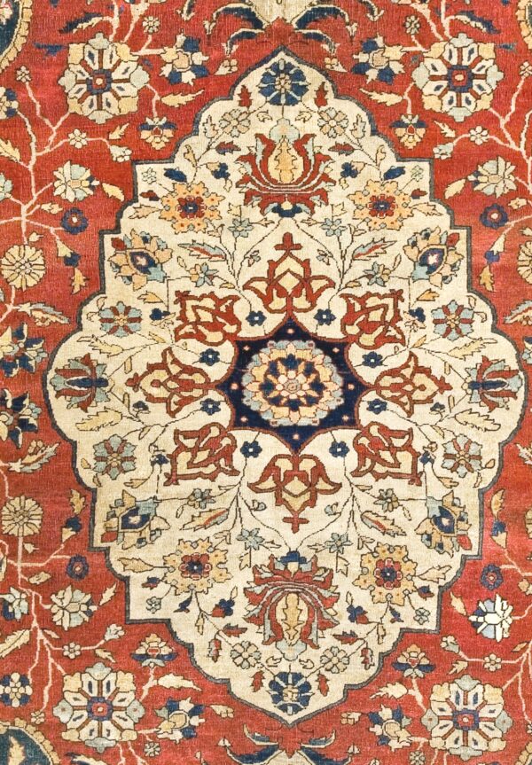 Close-up of a medallion detail on a red and cream antique persian rug by rugs on net