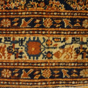 Close-up of the border pattern on an antique rug featuring rust, navy, and cream colors by Rugs On Net. by Rugs On Net