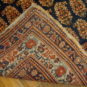 Close-up showing the backing and fringe of a dark blue and rust patterned rug by Rugs On Net. by Rugs On Net