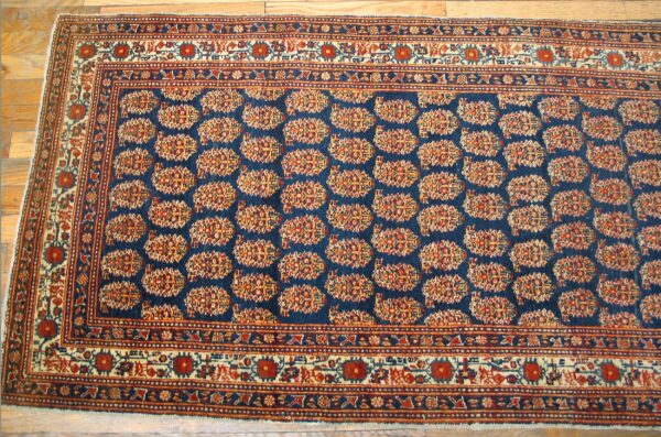 Close-up of a deep blue rug with repeating geometric medallions in red and gold, by rugs on net