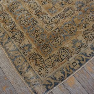Close-up corner detail of a distressed tan and blue patterned rug by Rugs On Net