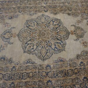 Close-up of a faded tan and blue traditional rug design by Rugs On Net