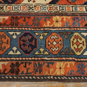 Close-up of geometric patterns in rust, blue, and cream on an antique rug by Rugs On Net