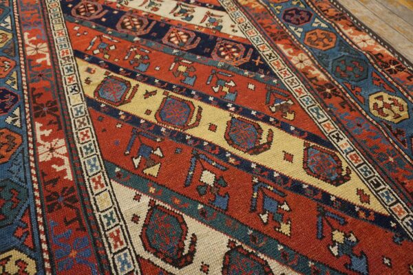 Close-up of a richly colored, antique caucasian rug with geometric patterns in red, blue, and cream by rugs on net. By rugs on net