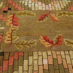 A hooked rug featuring a central field with autumn oak leaves and a brick-patterned border, by Rugs On Net. by Rugs On Net