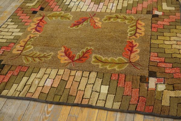 Close-up of a hooked rug featuring an autumnal oak leaf border design on a brown field, by rugs on net