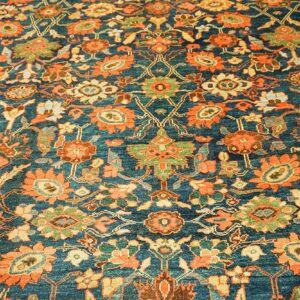 Close-up of a deep teal rug with intricate orange and green floral patterns, by Rugs On Net