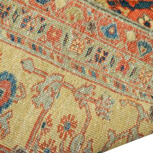 Close-up texture of an antique rug with geometric patterns in gold, red, and blue by Rugs On Net