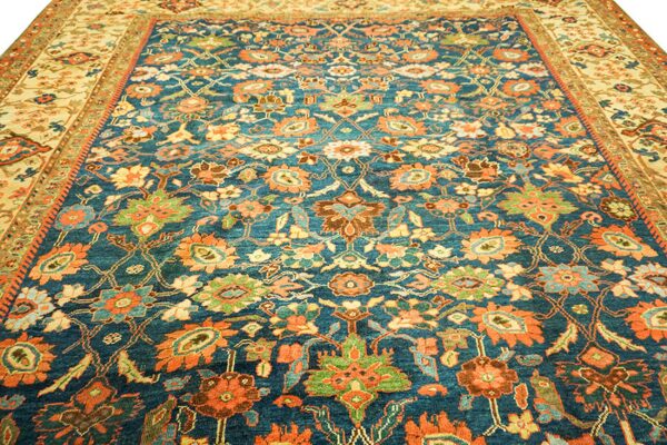 Close-up of a richly patterned blue rug with orange and green floral motifs by rugs on net