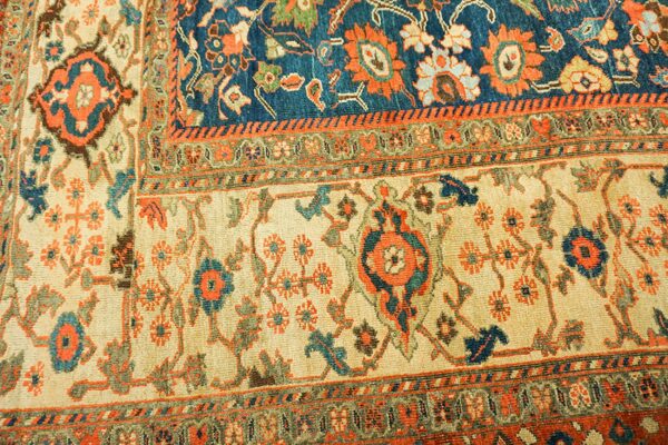 Close-up of a traditional rug with cream, blue, and orange motifs by rugs on net