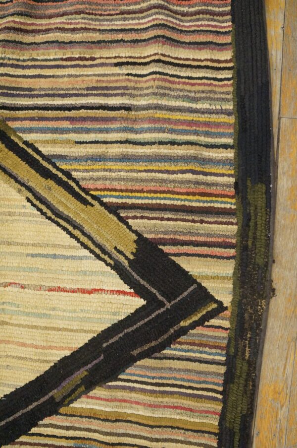 Close-up of a multicolored striped rug with a black and gold geometric design, by rugs on net. By rugs on net