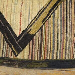 Close-up of a striped rag rug with a prominent black and olive V-shape pattern, by Rugs On Net