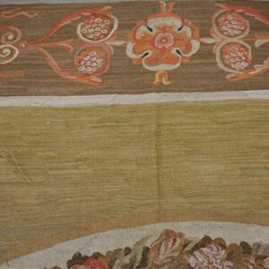 Close-up of a tapestry border featuring orange floral motifs on brown, next to a solid olive field, by Rugs On Net