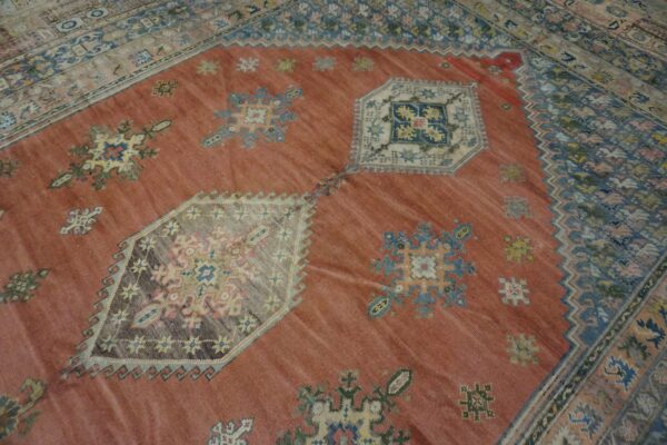 Close-up of a terracotta field rug with scattered geometric motifs and a detailed border, by rugs on net