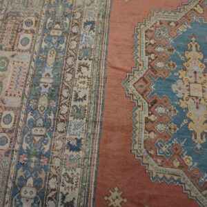 Close-up of an antique rug showing border and field patterns in pink, blue, and terracotta by Rugs On Net