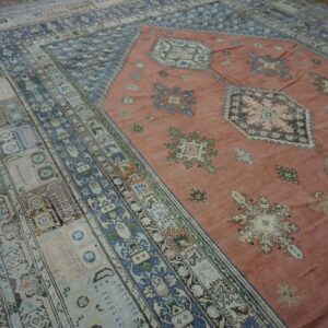 Close-up view of a vintage rug with a salmon field and intricate blue and beige borders by Rugs On Net