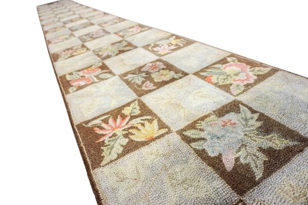 A long, narrow runner rug with a checkerboard pattern featuring floral motifs in brown and cream squares, by rugs on net. By rugs on net