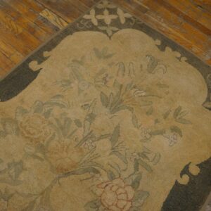 Close-up of a Vintage Scalloped Chinese Art Deco Rug showing the tan field, green floral design, and dark scalloped edge on a wood floor by Rugs On Net