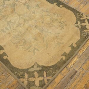 Close-up of a beige and olive green floral rug corner on wood flooring by Rugs On Net