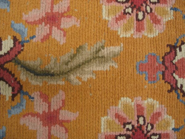 Close-up of a vibrant orange rug with pink and blue floral details, by rugs on net