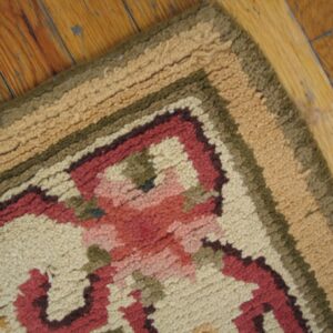 Close-up of a floral pattern rug border with beige, red, and green tones on a wood floor by Rugs On Net. by Rugs On Net