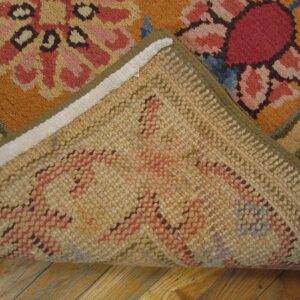 Close-up of the corner of a colorful rug, showing the backing fabric, by Rugs On Net