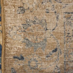 Close-up of the edge binding and woven texture of a vintage blue and beige rug by Rugs On Net. by Rugs On Net