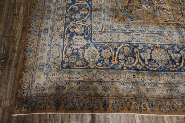 Close-up of a blue and gold traditional rug border on wood flooring by rugs on net