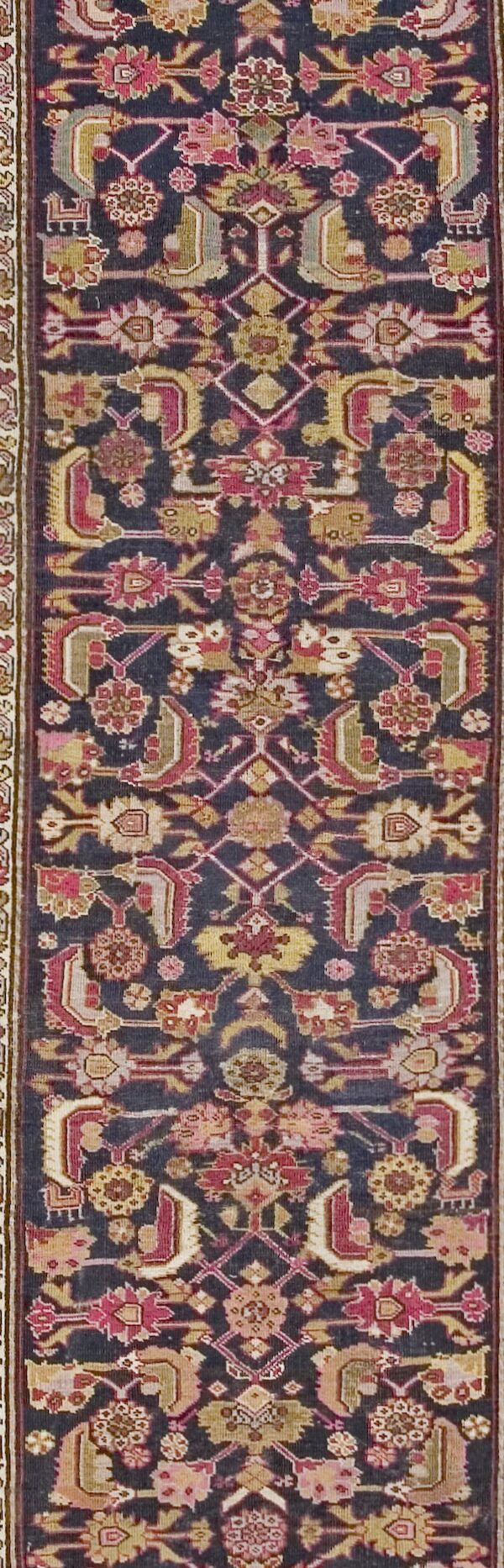 Close-up of a dark field runner rug with intricate geometric and floral motifs in deep reds and golds by rugs on net. By rugs on net