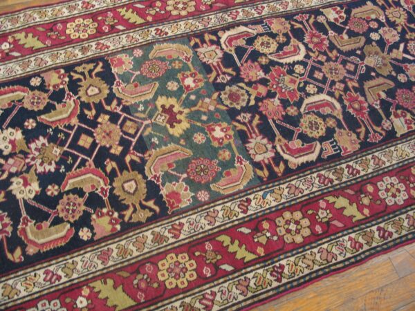 Close-up of a richly colored rug with geometric and floral motifs in navy, red, and teal, by rugs on net. By rugs on net