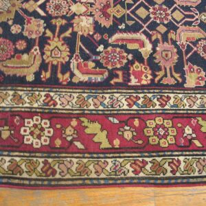 Close-up of a dark blue field rug with stylized animal motifs and a detailed border by Rugs On Net