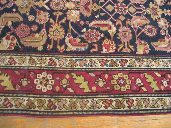 Close-up of a dark blue field rug with stylized animal motifs and a detailed border by rugs on net