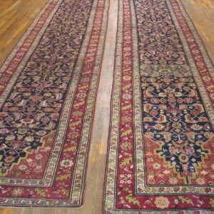 Two long, ornate Persian runners with dark blue fields and rich red borders on a wooden floor by Rugs On Net. by Rugs On Net