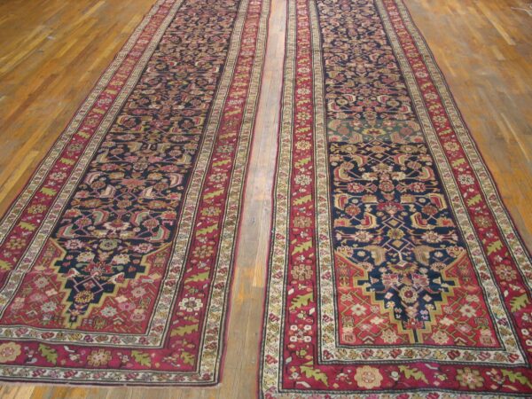 Two long, ornate persian runners with dark blue fields and rich red borders on a wooden floor by rugs on net. By rugs on net