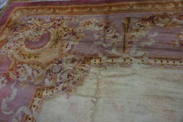 Close-up of a faded floral rug with pink and gold tones by rugs on net