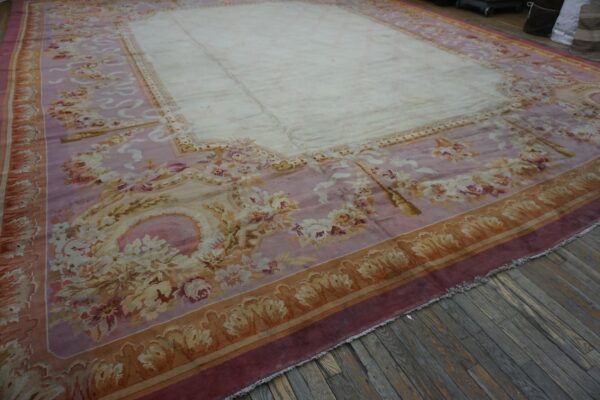 Close-up view of a large floral rug with pink and cream tones by rugs on net