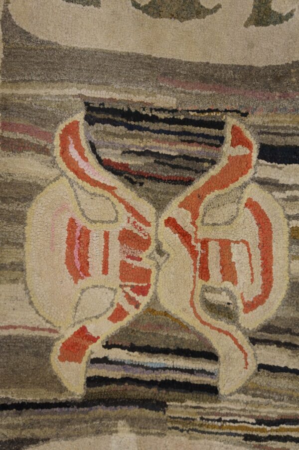 Close-up of a hooked rug featuring symmetrical abstract shapes in cream and orange against a striped brown background, by rugs on net