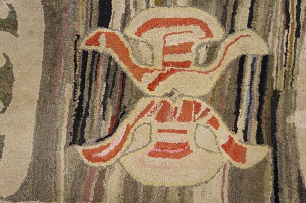 Close-up of an abstract motif in a hooked rug, featuring beige and orange shapes against a variegated brown background, by rugs on net. By rugs on net