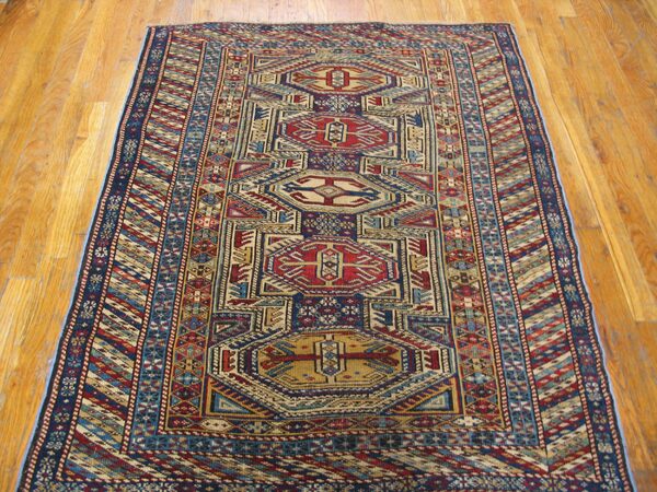 A vibrant geometric runner rug with red, blue, and beige patterns on a light wood floor by rugs on net. By rugs on net