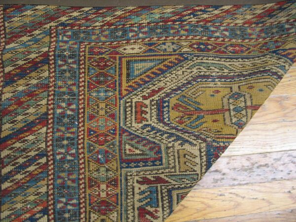 Close-up corner detail of a richly patterned antique rug featuring geometric borders and earthy tones by rugs on net. By rugs on net