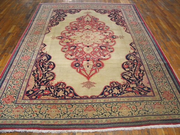 A large traditional rug with a beige field and intricate red and navy floral patterns, by rugs on net. By rugs on net