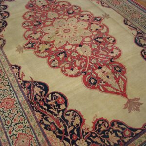 Close-up of a beige field carpet featuring red and dark blue floral medallion elements and intricate borders, by Rugs On Net