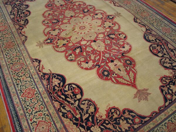 Close-up of a beige field carpet featuring red and dark blue floral medallion elements and intricate borders, by rugs on net