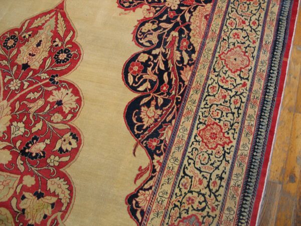 Close-up of a beige carpet with intricate red and navy floral borders, by rugs on net
