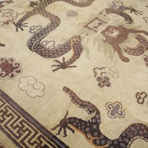 Close-up of a beige rug featuring brown and purple dragon motifs and cloud patterns, by Rugs On Net