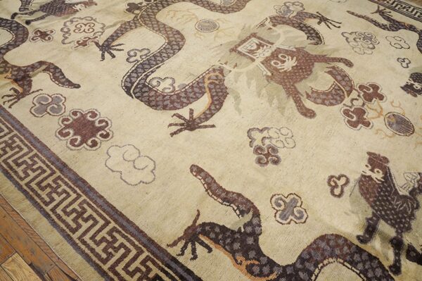 Close-up of a beige rug featuring brown and purple dragon motifs and cloud patterns, by rugs on net