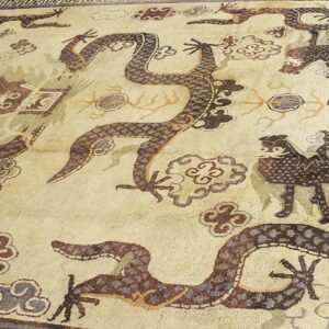 Close-up of a light-colored rug featuring dark, stylized dragons and cloud motifs, by Rugs On Net