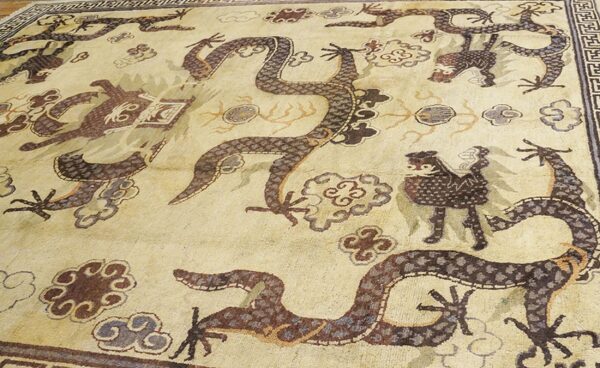 Close-up of a light-colored rug featuring dark, stylized dragons and cloud motifs, by rugs on net