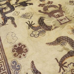 Close-up of a beige rug featuring dark brown and purple dragon motifs and cloud patterns, with a geometric border, by Rugs On Net